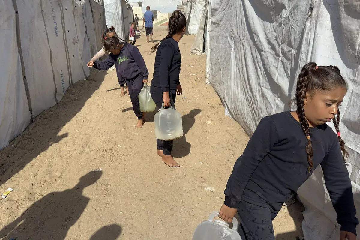 Girls collect water from water trucks in Al Yamourk camp in Deir al Balah, middle area of the Gaza Strip.  Photo: UN Women/Sulaiman Hejji