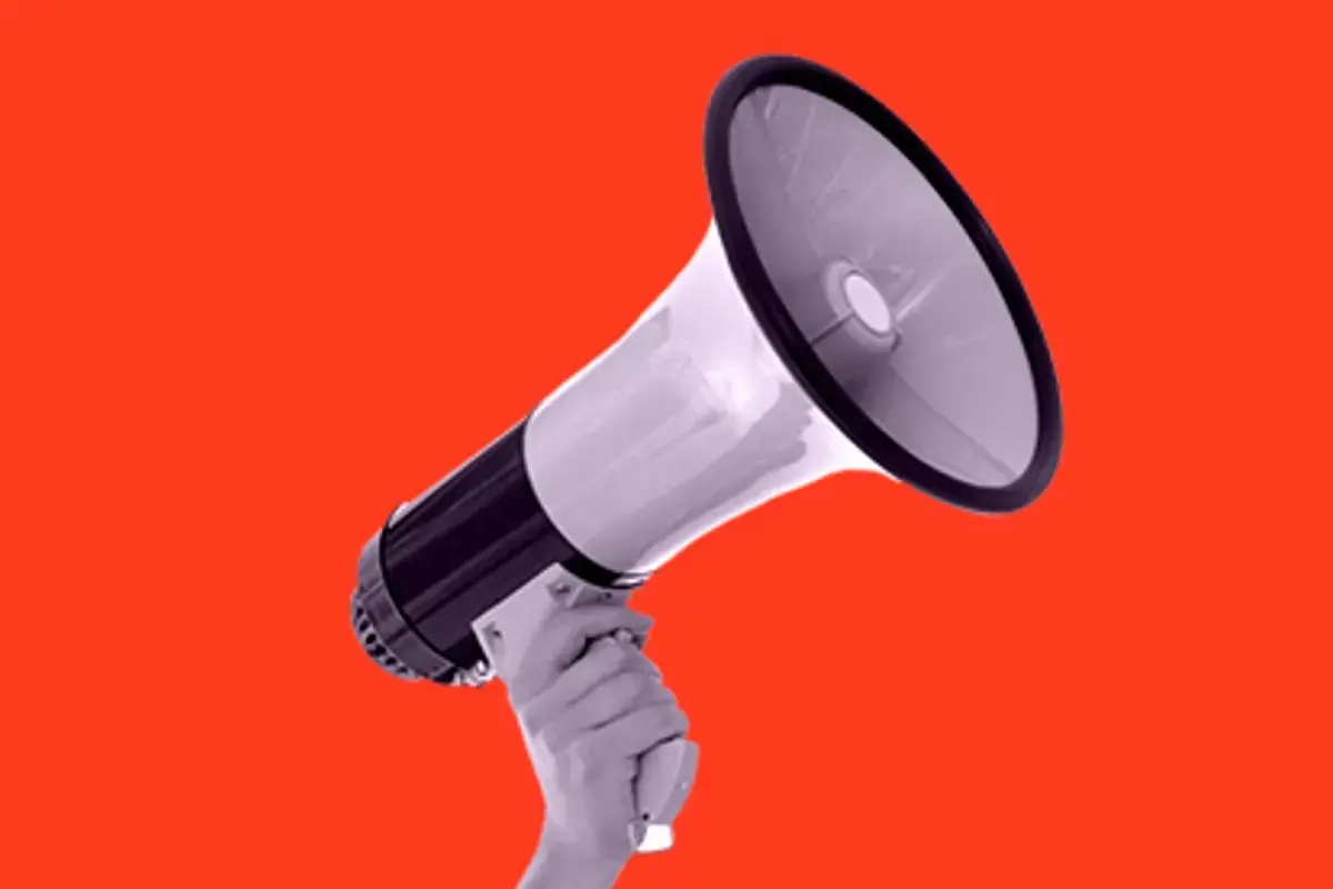 A female hand holds a loud speaker